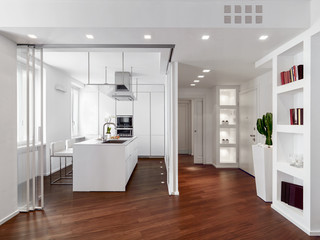 modern kitchen interior with kitchen island and wooden floor near to main door