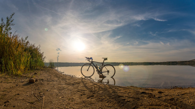 Triathlon road bike standing at a beach at a beautiful sunset