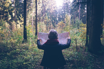 Young traveler woman with map,at autumn green forest in sunny day. Relaxing outdoor, hiking...