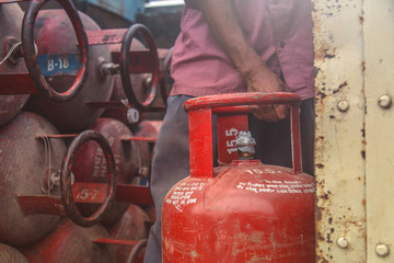 Worker delivering LPG gas cylinders into the truck for customers