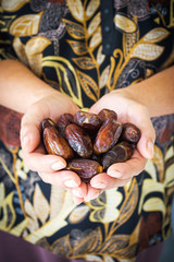 Woman's hand holding dried date fruit. High nutrition fruit. Arabic favorite fruit.