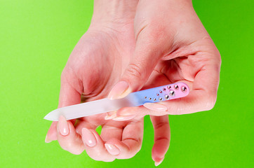 Manicure nail woman glass nail file on green background