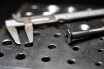 steel plate with a screw and a caliper