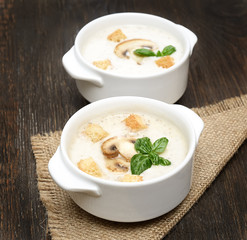 champignon soup with crackers on wooden background