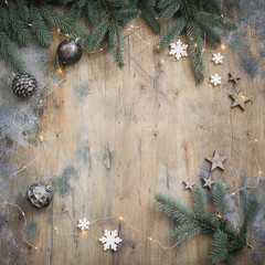 Christmas dark flat lay composition with fir branches, stars and black balls on wooden vintage background