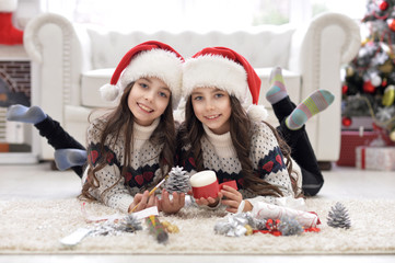 Portrait of cute sisters preparing for Chrismas