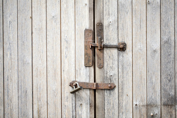 Cerrojo oxidado en puerta de madera