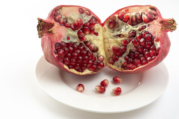 pomegranate and pomegranate seeds isolated on white background