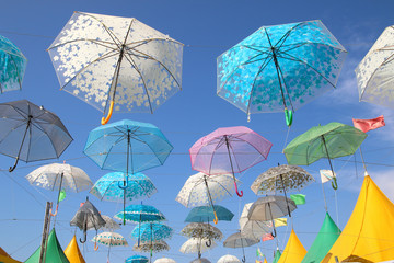 floreados paraguas abiertos de colores en un cielo azul de verano para dar sombra en un mercadillo