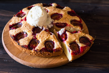 Homemade plum pie on the old wooden background. Still life of food. plum tart. Autumn harvest. Old fashion cuisine. Portion. Plum bakery. Rustic open pie. Winter pie. New York pie. Ice cream.