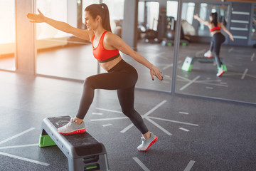 Adult sportswoman training with stepper
