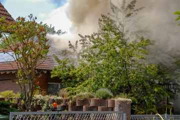 Fototapeta na wymiar Haus brennt und Qualmt