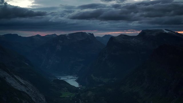 Clouds moving over mountains landscape. Evening view on green valley and fjord Geirangerfjord from Dalsnibba viewing point, Nor