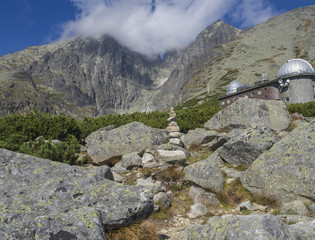 Obraz premium View on mountain Peak Lomnicky stit 2 634 m covered in clouds at Summer with Skalnate pleso Observatory, second highest mountain peak in the High Tatras mountains of Slovakia, Vysoke Tatry