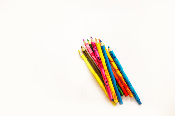colored pencils are on the school notebook. Notebook lies on the Desk at school. the kids are learning.