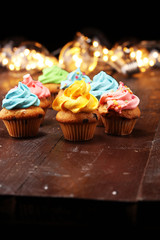 Tasty cupcakes on christmas winter background. Birthday cupcake in rainbow colors.