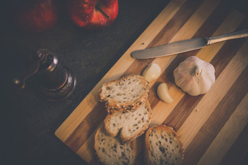 Tomato Basil and garlic Bruschetta on a dark, moody kitchen board.