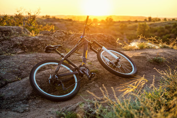 Fototapeta na wymiar Bicycle lying on the sunset background, free space.