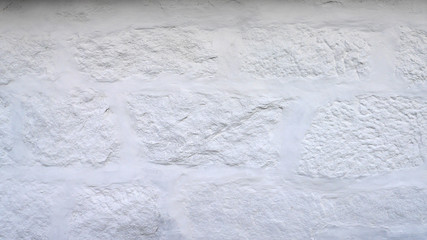 Rustic white wall texture and background. Uneven, imperfect old bricks with brand new coat of whitewash. With copy space