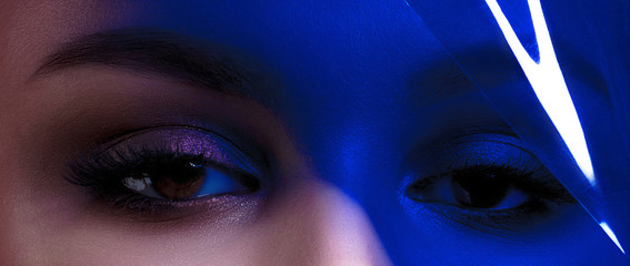 Eyes of young beautiful woman with clean perfect skin with blue filter