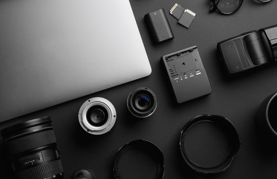 Flat lay composition with professional photographer equipment on dark background