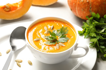 Bowl with tasty pumpkin soup served on table