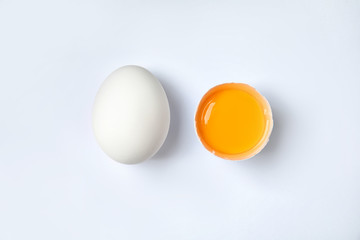 Raw chicken eggs with yolk on white background, top view