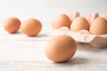 Raw brown chicken egg on wooden table, closeup
