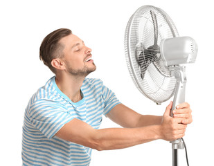 Man refreshing from heat in front of fan on white background