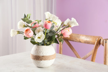 Vase with beautiful flowers as element of interior design on table in room