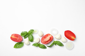 Fresh green basil leaves, tomatoes and mozzarella on white background, top view