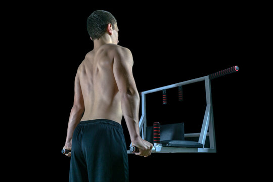 Young man exercising on the home parallel bars.