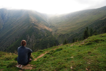 A woman sitting by Mount Suru of Carpathian Mountains in Romania