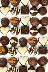 Assortment of chocolate candies from black, milk and white chocolate with nuts and marzipan
