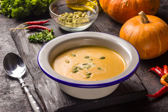 Seasonal autumn food - Spicy pumpkin soup with cream and pumpkin seeds.