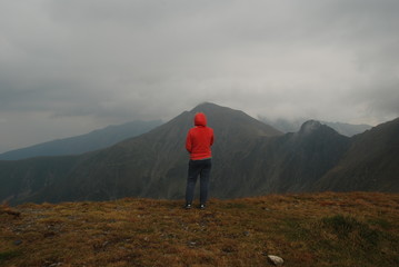 A woman enjoying beautiful view of Carpathians, Fagaras Mountains of Transylvania, Romania