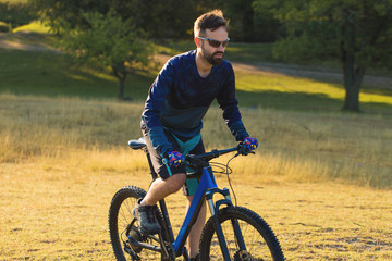A cyclist rides the hills, Beautiful portrait of a guy on a blue bicycle