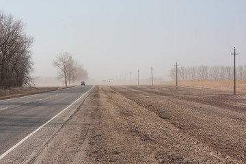 Dust storm in early spring. Wind picks up dust from the fields