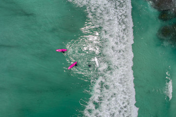 Surfers in tropical ocean waiting wave. Aerial view made with drone