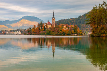 Bled lake and pilgrimage church with autumn mountain landscape background
