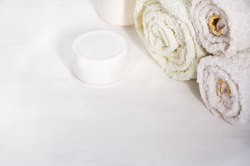 White towels cream jar on white background for cosmetic procedures