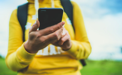 tourist girl on background grass using mobile smartphone closeup, women holding in female hands gadget technology, hiker texting finger message on screen content online wifi internet lifestyle concept