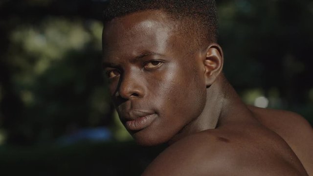 Angry Black Shirtless African Man Turning And Staring At Camera