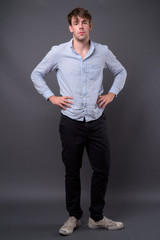 Studio shot of young handsome man against gray background