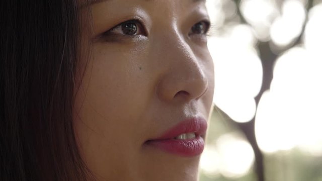 close up on asian young woman cosing her eyes-outdoor