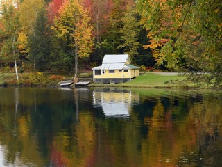 Fototapeta na wymiar Yellow Cabin Reflection on Calm Autumn Lake