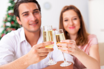 Young couple celebraring christmas with champagne