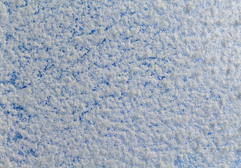 Close-up of snow texture in front of blue sky