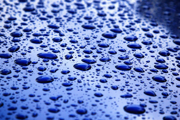 rain drops on blue car body, shallow focus