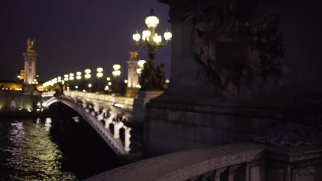 Light posts and sculptures on famous French bridge at night in Paris France
